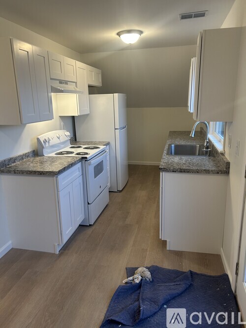 A kitchen with white cabinets and a granite countertop.