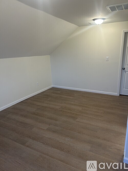 A room with wooden flooring and a white door.