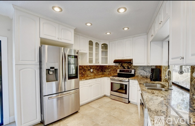 A kitchen with white cabinets and stainless steel appliances.