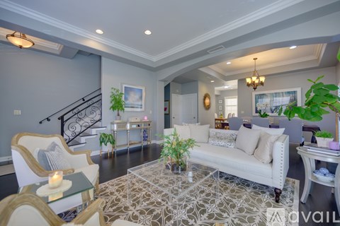 A living room with a white couch and a glass coffee table.