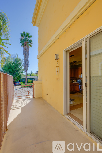 A yellow building with a glass door and a palm tree in the background.