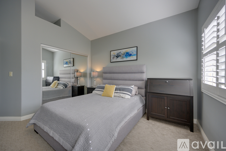 A bedroom with a large bed and a painting on the wall.