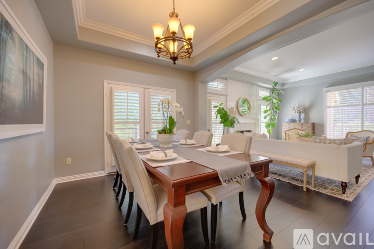 A well-lit dining room with a wooden table and chairs.