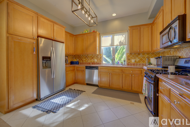 A kitchen with wooden cabinets and a stainless steel refrigerator.