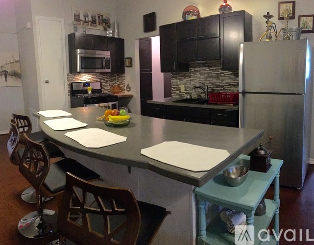 A kitchen with a large island and a refrigerator.