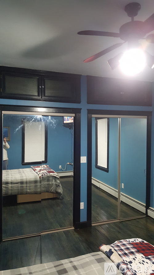 A bedroom with a bed and a ceiling fan.