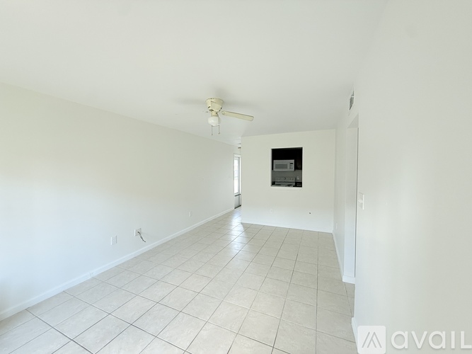 A spacious room with a tiled floor and a ceiling fan.