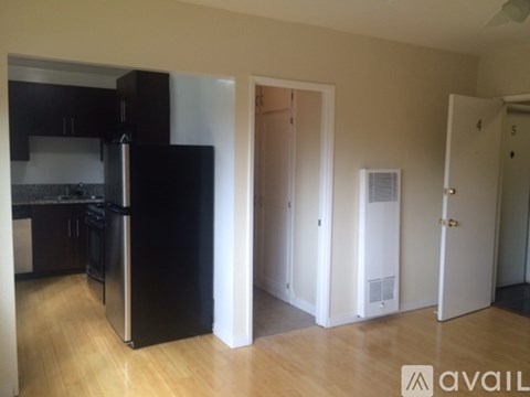 A kitchen with black cabinets and a stainless steel refrigerator.