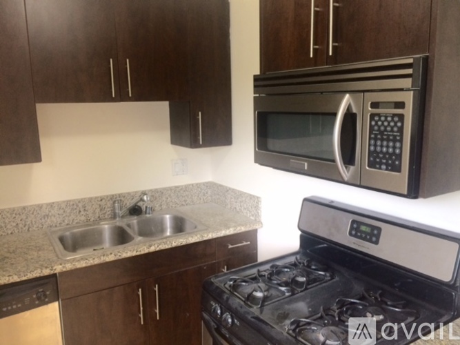 A kitchen with a stove, sink, and microwave.