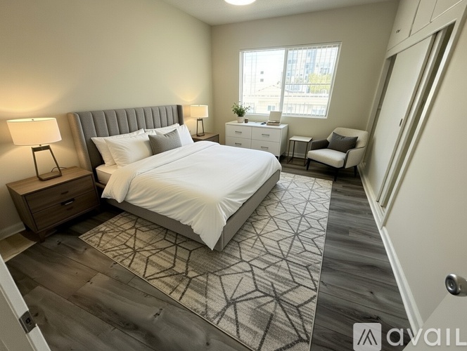 A bedroom with a large bed and a chair.