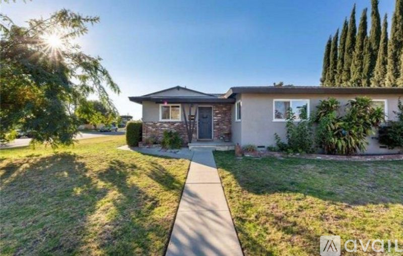 A house with a front yard and a sidewalk leading to the front door.