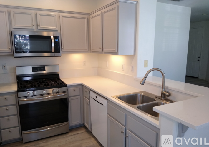 A kitchen with white cabinets and a stainless steel oven.