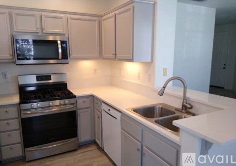 A kitchen with white cabinets and a stainless steel oven.