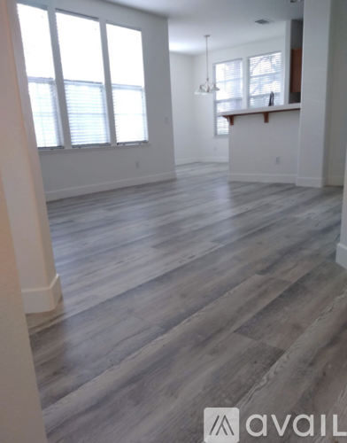 A room with wooden flooring and a bar area.