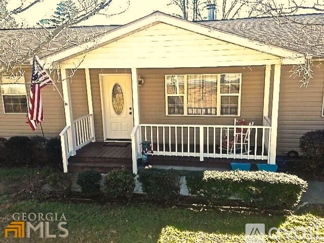 A house with a porch and an American flag hanging on the wall.
