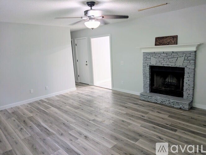 A room with a fireplace and a ceiling fan.