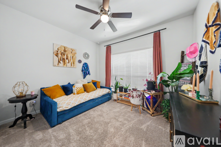 A bedroom with a blue bed and a ceiling fan.