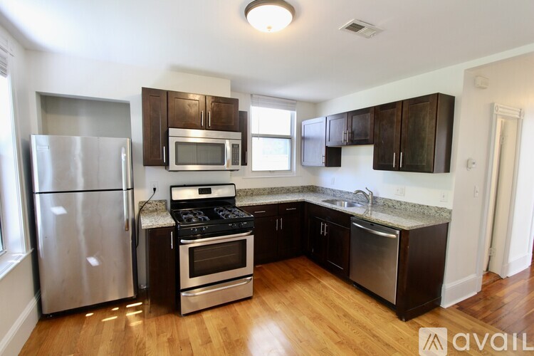 A kitchen with wooden floors and stainless steel appliances.