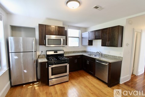 A kitchen with wooden floors and stainless steel appliances.