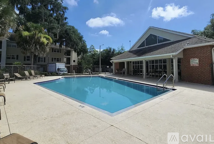A pool in a backyard with a building in the background.