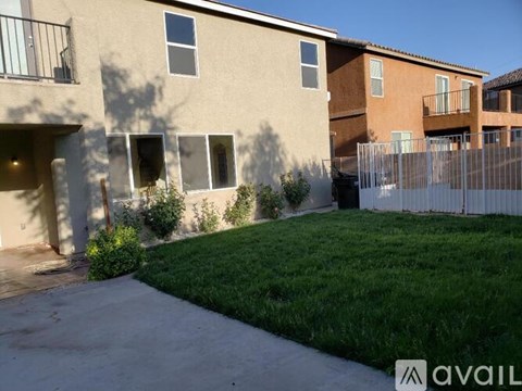 A building with a fence and green grass in front.