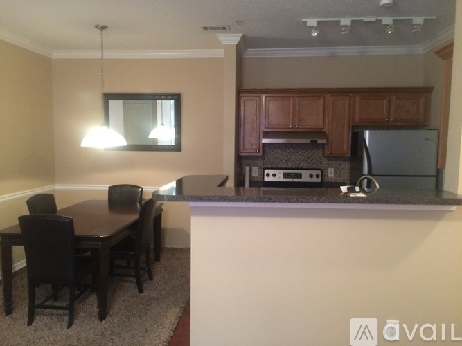 A kitchen with a table and chairs in front of it.