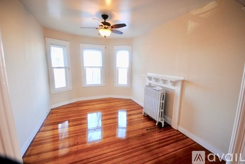 A room with wooden floors and a ceiling fan.