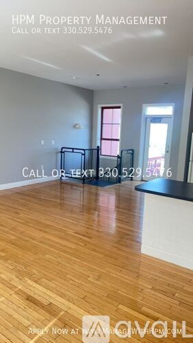 A room with wood flooring and a large window.