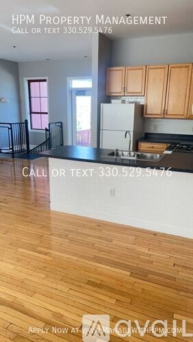 A kitchen with wooden floors and a white refrigerator.