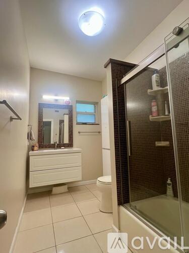 A bathroom with a walk-in shower and a vanity with a mirror.