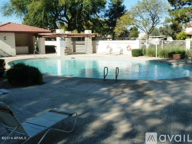 A pool with a chair and a house in the background.
