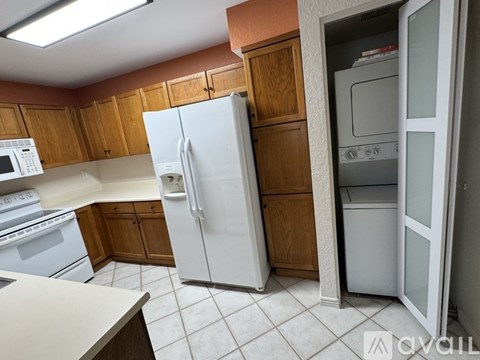 A kitchen with a white refrigerator and white oven.