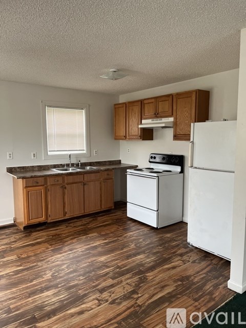 A kitchen with wooden cabinets and a white refrigerator.