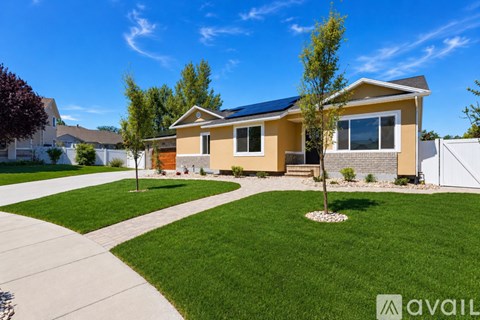 A house with a yellow exterior and a white fence in the background.