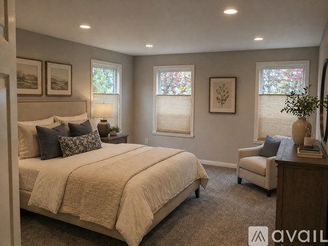 A bedroom with a large bed and a chair.
