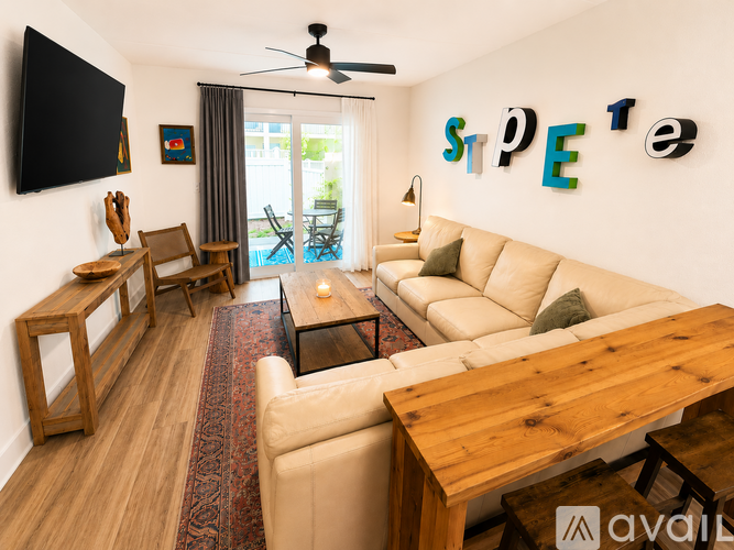 A living room with a couch, chairs, and a television.