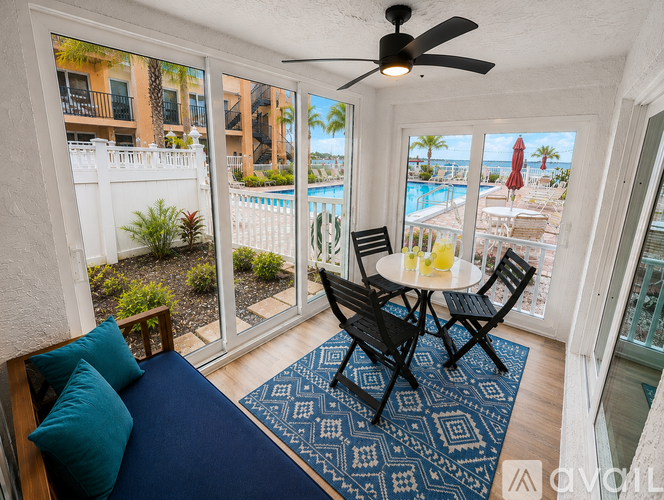 A balcony with a table and chairs overlooking a pool.