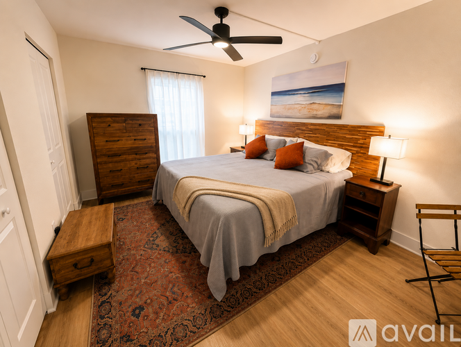 A bedroom with a bed, nightstand, and a ceiling fan.
