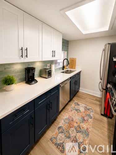 A kitchen with dark blue cabinets and a white countertop.