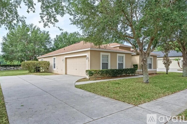 A house with a driveway and a tree in front.