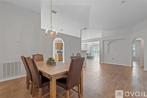 A dining room with a wooden table and chairs.