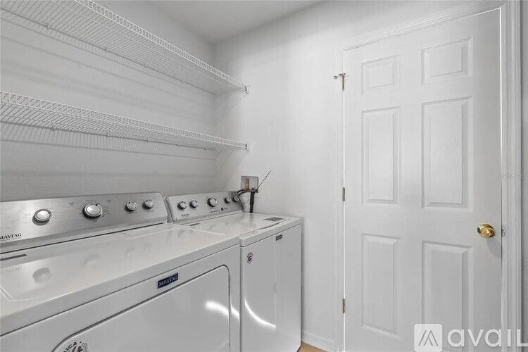 A white laundry room with a washer and dryer and a white door.