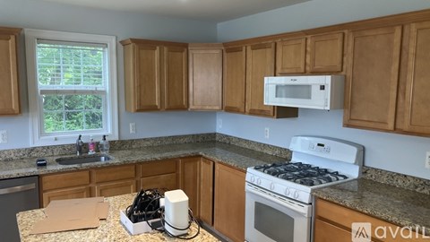 A kitchen with wooden cabinets and a white stove top oven.