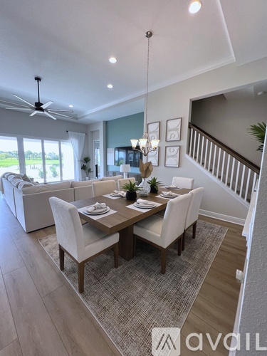 A dining room with a table set for two and a ceiling fan.