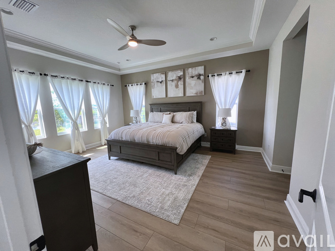 A bedroom with a large bed and a ceiling fan.