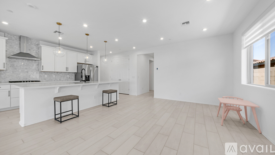 A modern kitchen with white cabinets and a bar area.