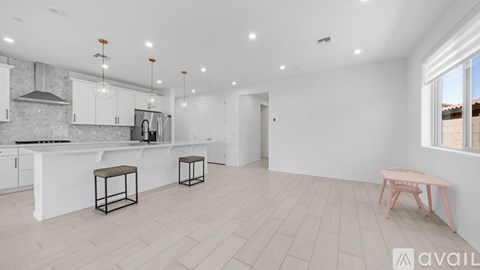A modern kitchen with white cabinets and a bar area.