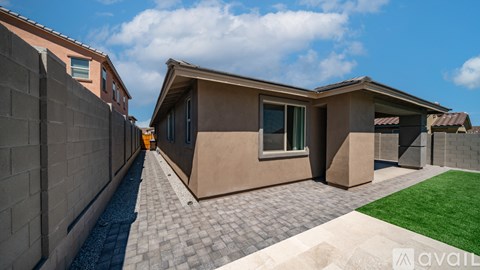 A modern house with a beige exterior and a grey tiled walkway.