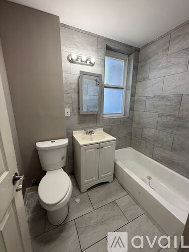 A bathroom with a toilet, sink, and bathtub.