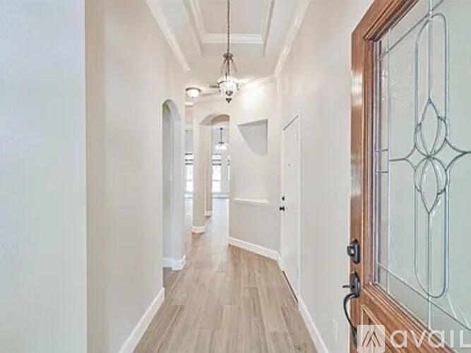 A hallway with a wooden floor and white walls.